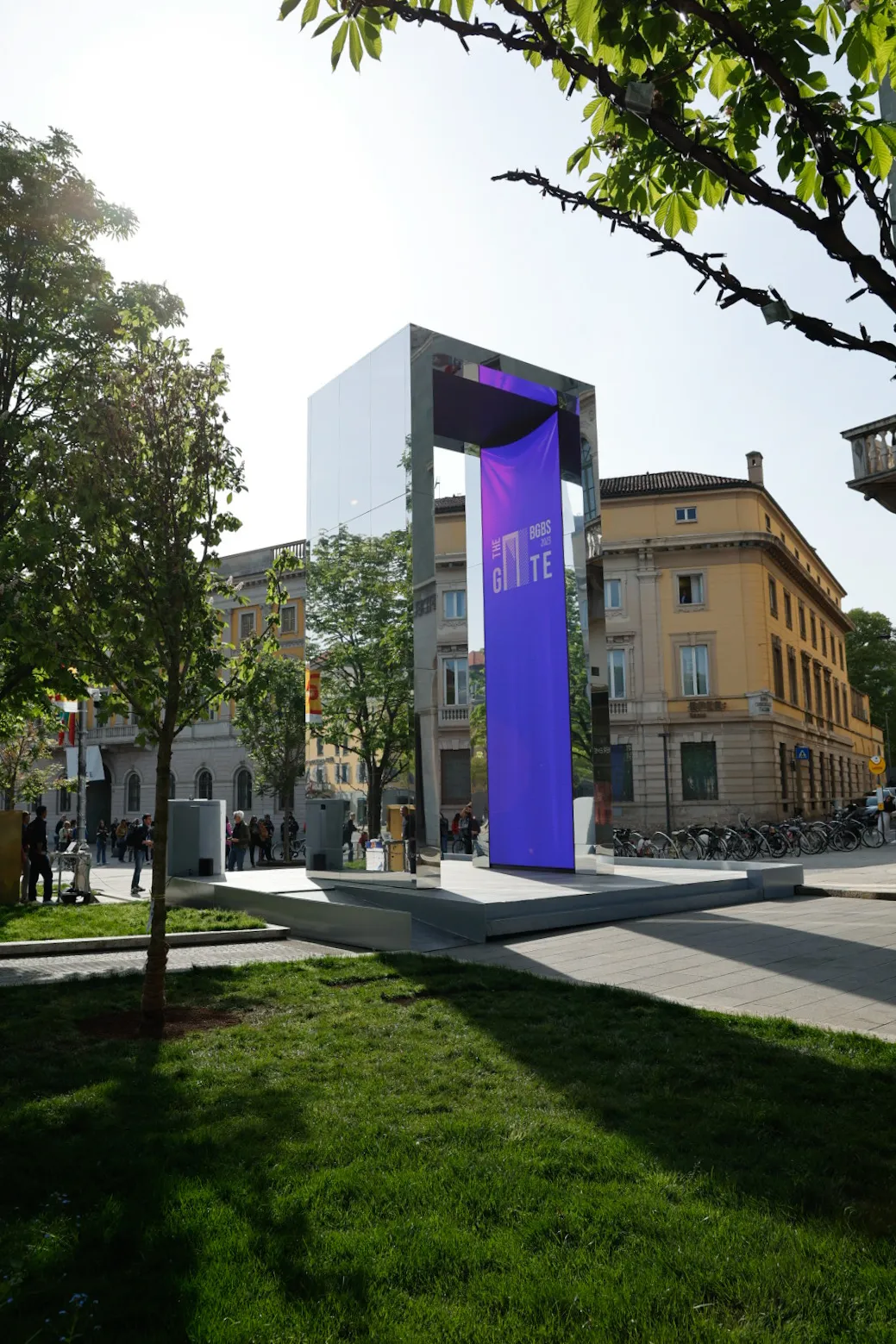 A large blue sign sitting in the middle of a park.