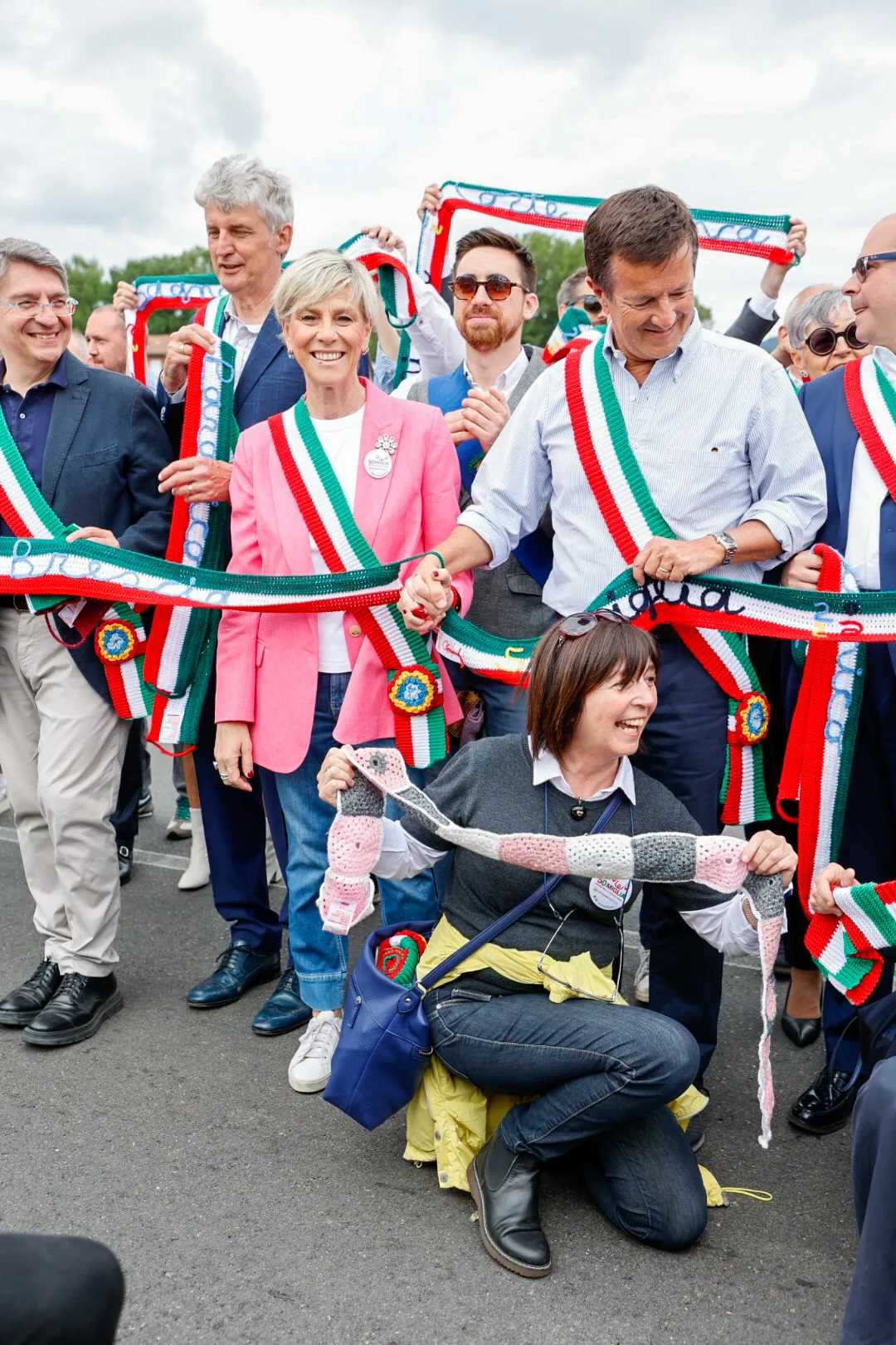 A group of people are holding a ribbon.