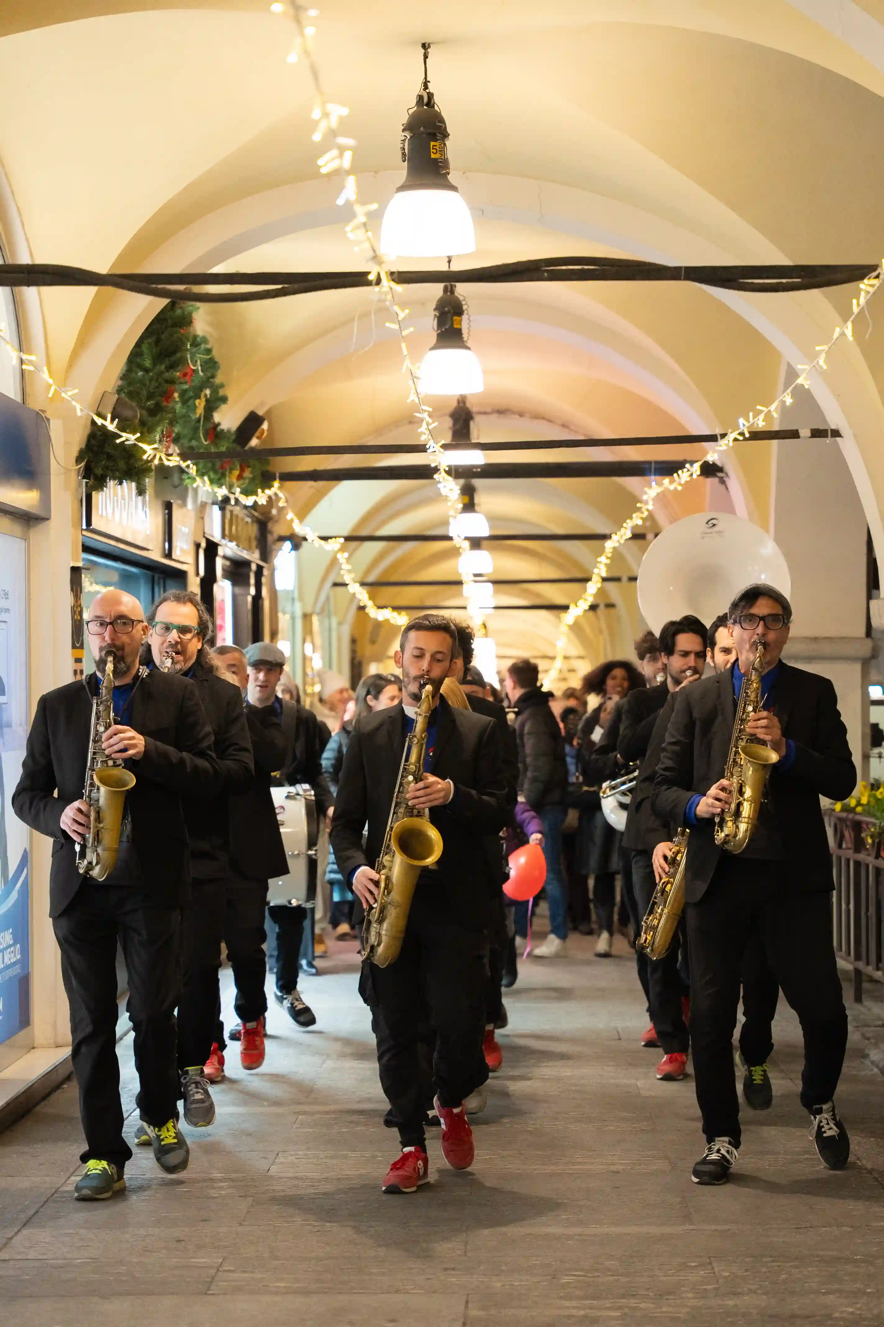 A group of people walking down a hallway with musical instruments.