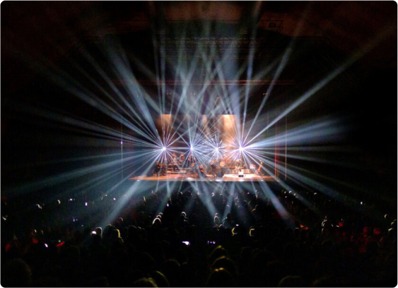 A concert scene with bright lights and a stage.