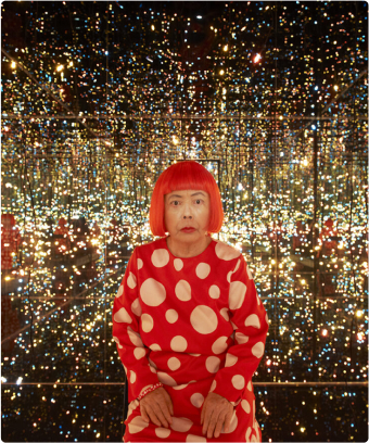 A woman with red hair sitting in front of a wall of lights.