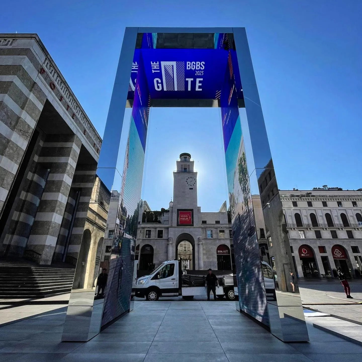 The entrance to a building with a clock tower in the background.